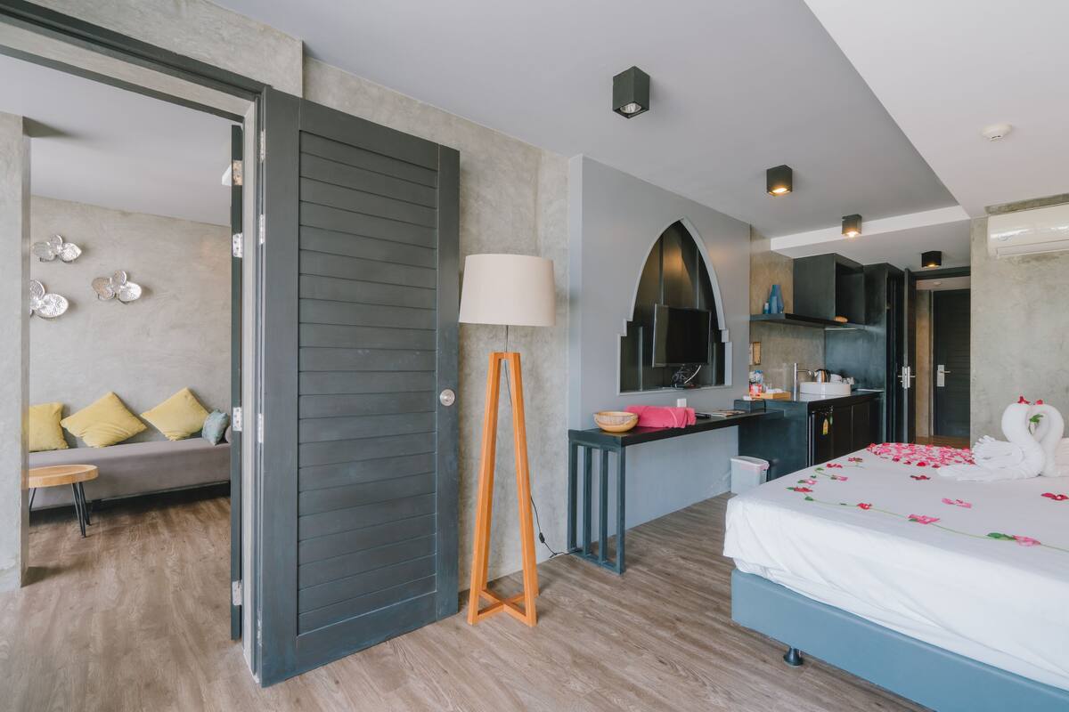 Ein modernes Hotelzimmer mit Bett, Schreibtisch, Sofa und Bad.