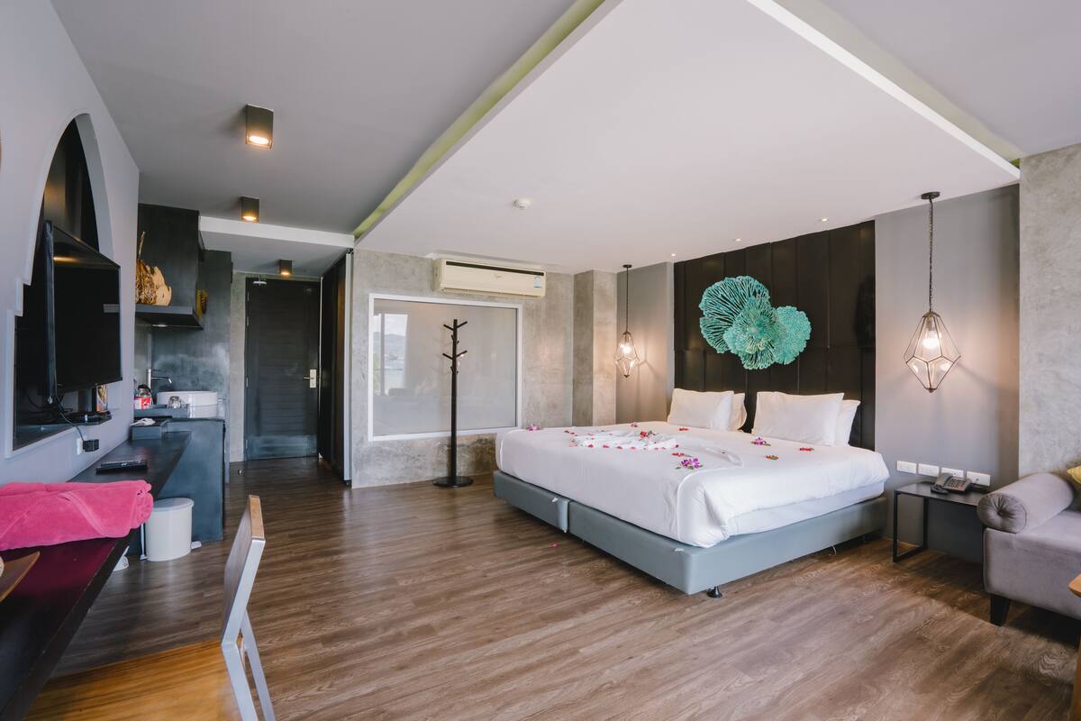 Ein modernes Schlafzimmer mit einem großen Bett, Nachttischen, einem Schreibtisch und einem Kleiderschrank.