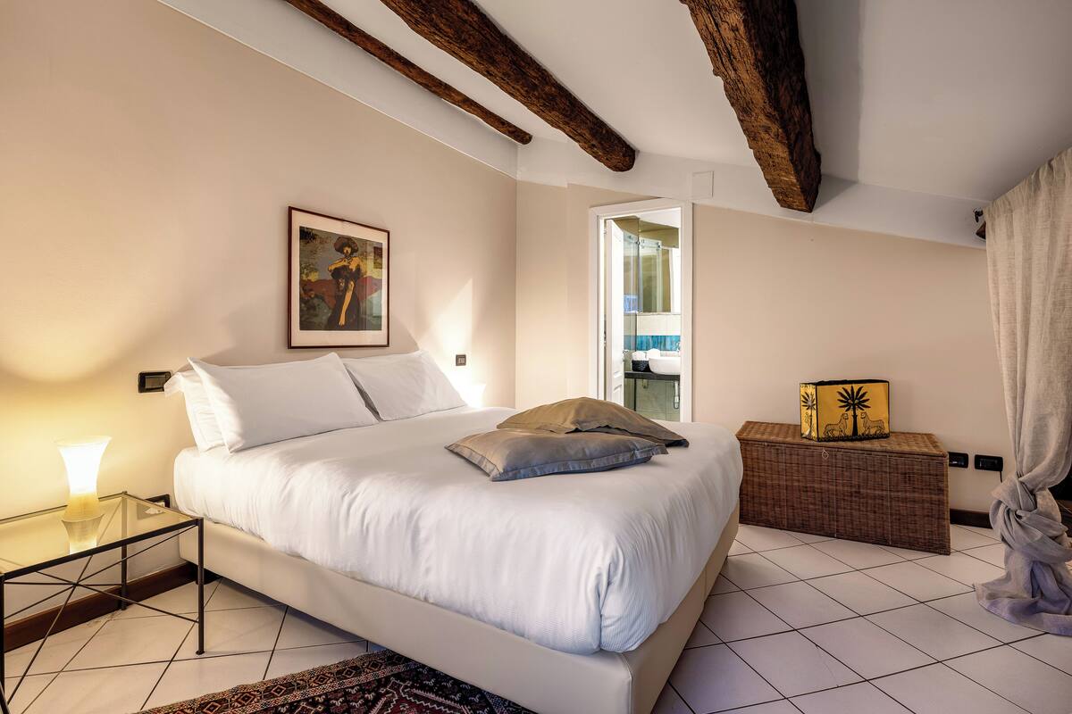 A bedroom with a bed, bedside table, and a small cabinet.