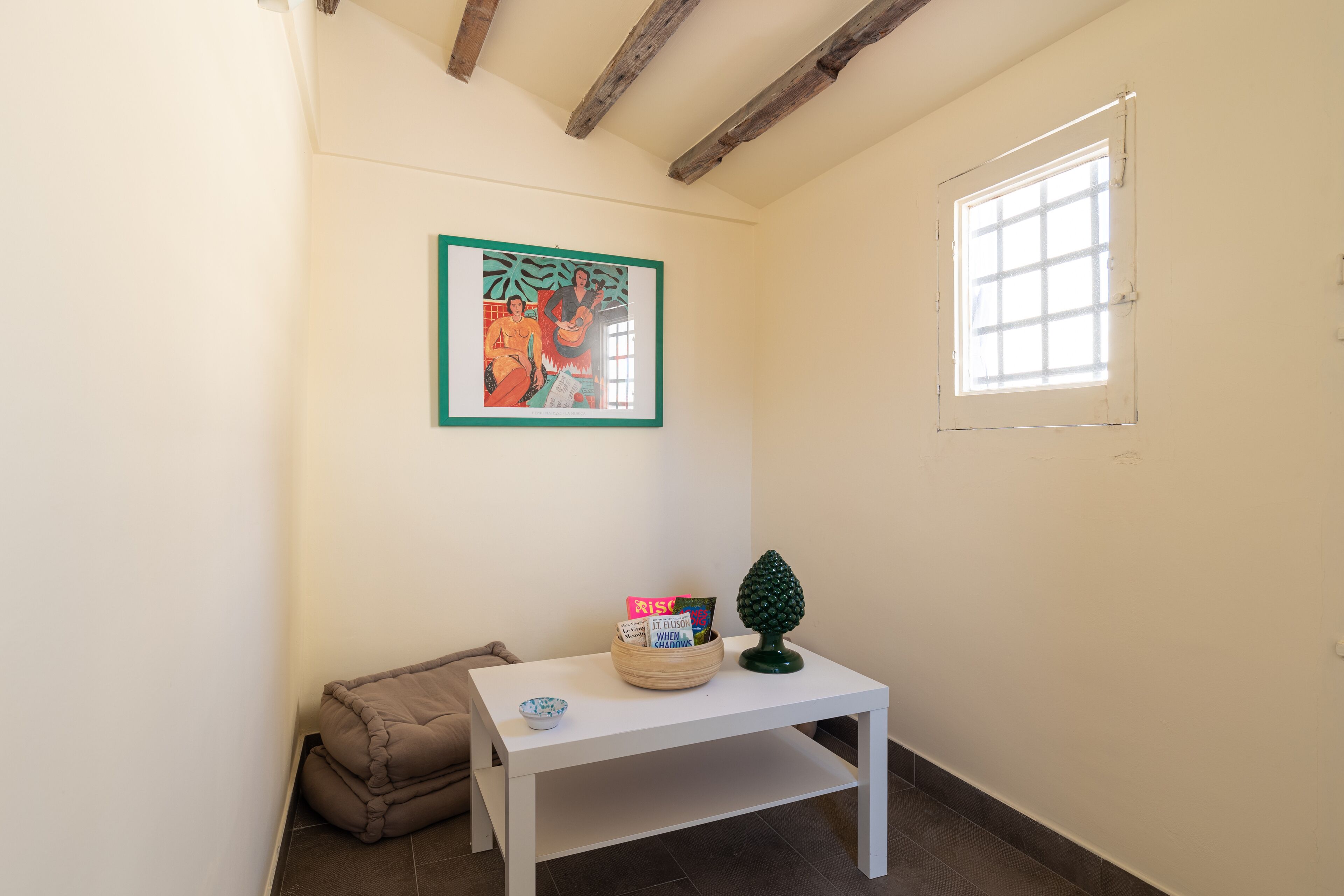 A small room with a white table, a framed picture, a window, and a door.