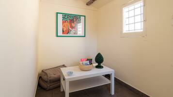 A small room with a white table, a framed picture, a window, and a door.