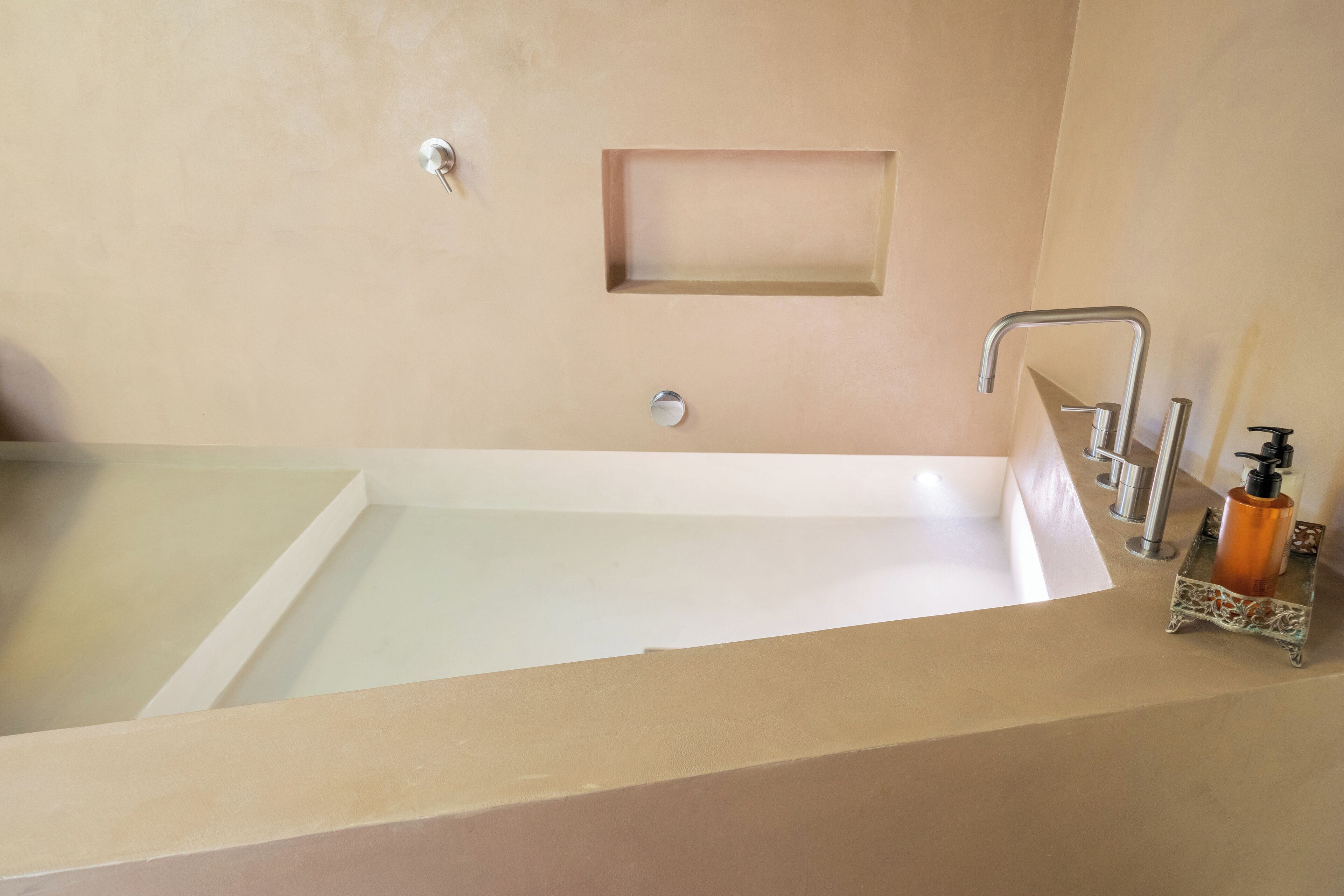 Une salle de bain avec une baignoire, un lavabo et un miroir.