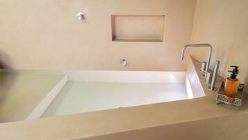 Une salle de bain avec une baignoire, un lavabo et un miroir.