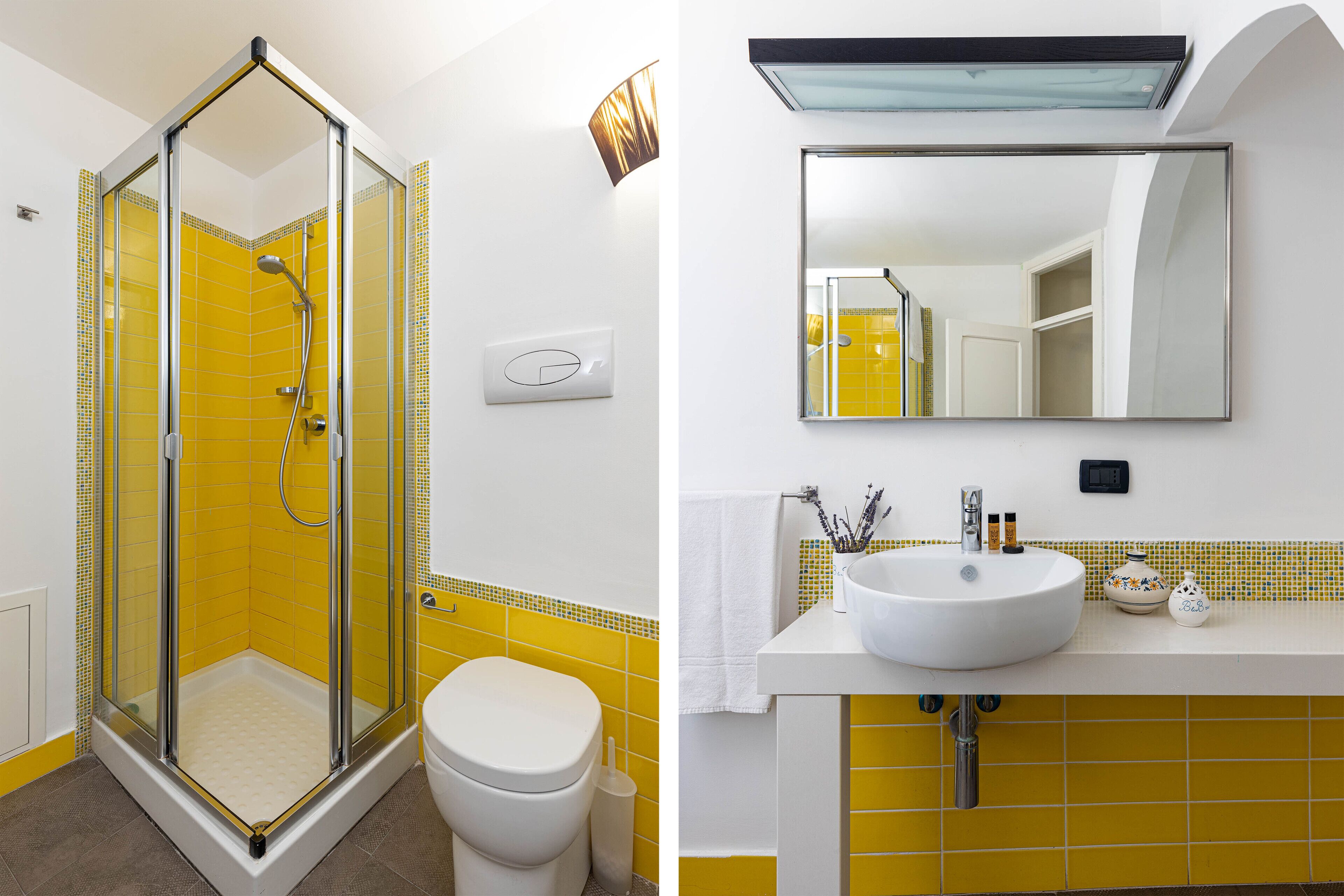 A bathroom with a glass shower enclosure, a white toilet, and a sink with a mirror above it.