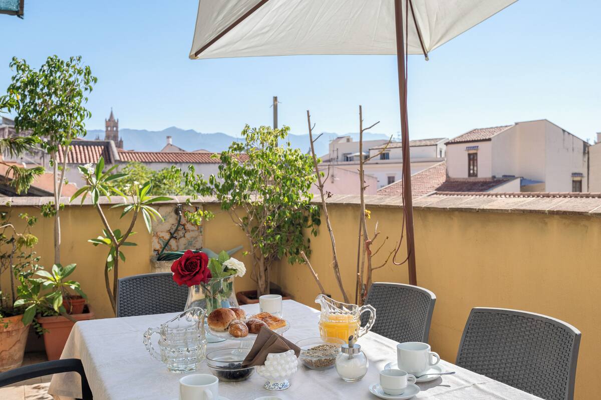 A table set for breakfast with a view of buildings and mountains in the background.