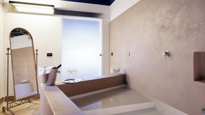 Un baño moderno con un espejo grande, una bañera y una ventana que deja entrar luz natural.