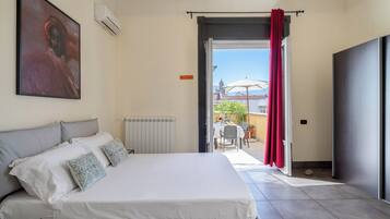 Un dormitorio con una cama, un radiador y vistas a un patio exterior.