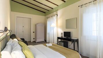 Una habitación de hotel con cama, escritorio, televisión y armario.