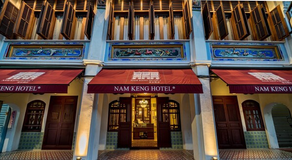 The facade of Nam Keng Hotel with traditional architectural elements, including wooden shutters and decorative tiles. - Nam Keng Hotel (George Town)