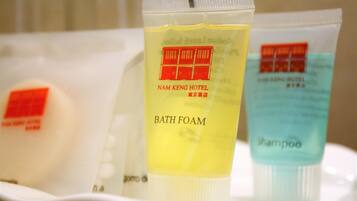 Articoli da bagno come schiuma da bagno e shampoo su un vassoio.