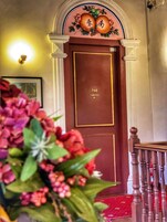 A wooden door with the number 201 and the word "MOBILITY" on it, flanked by white columns and a decorative arch above.
