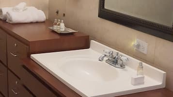 Een badkamer met een wit wastafel, een spiegel en een handdoekrek.