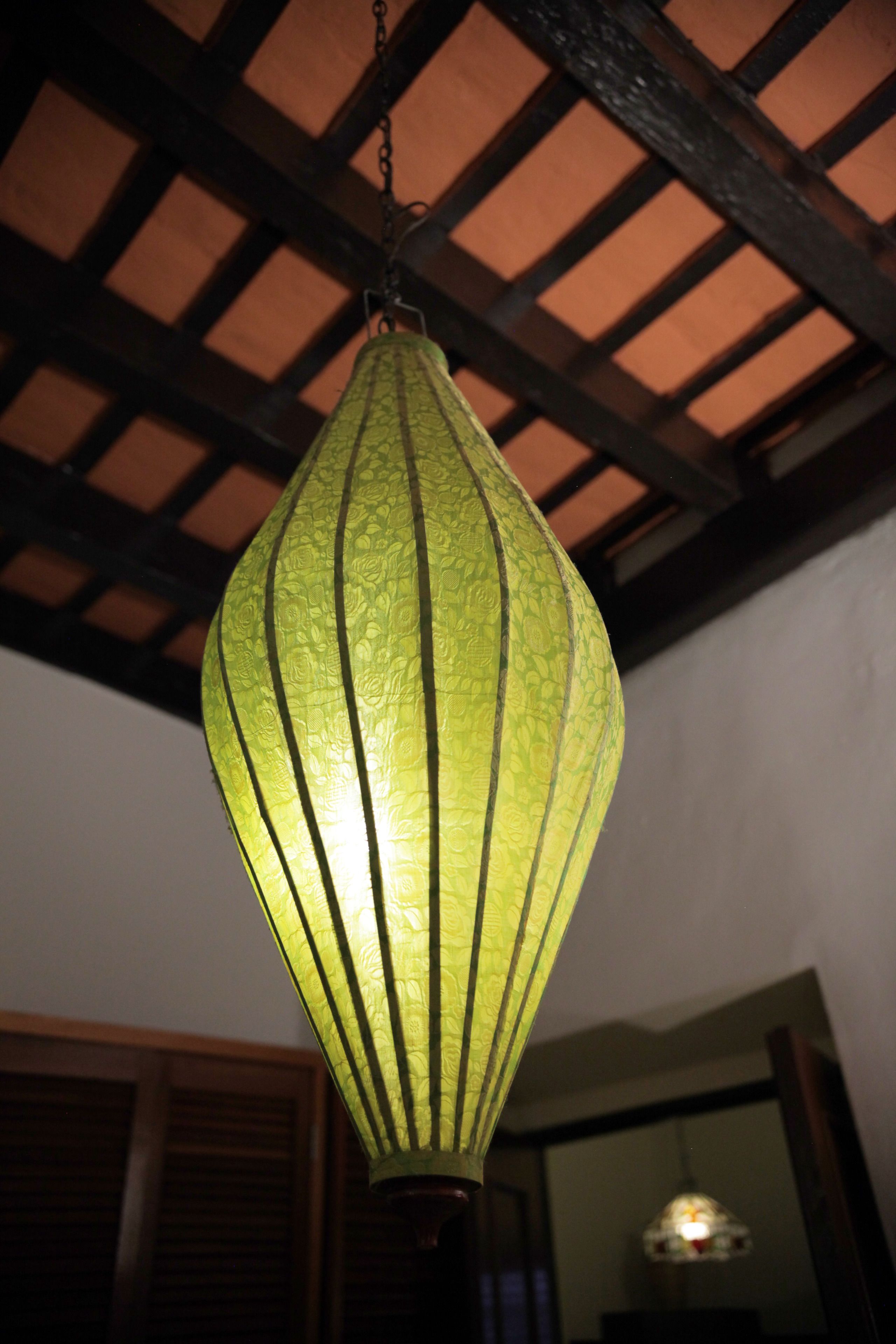 A hanging green lantern with a textured surface.