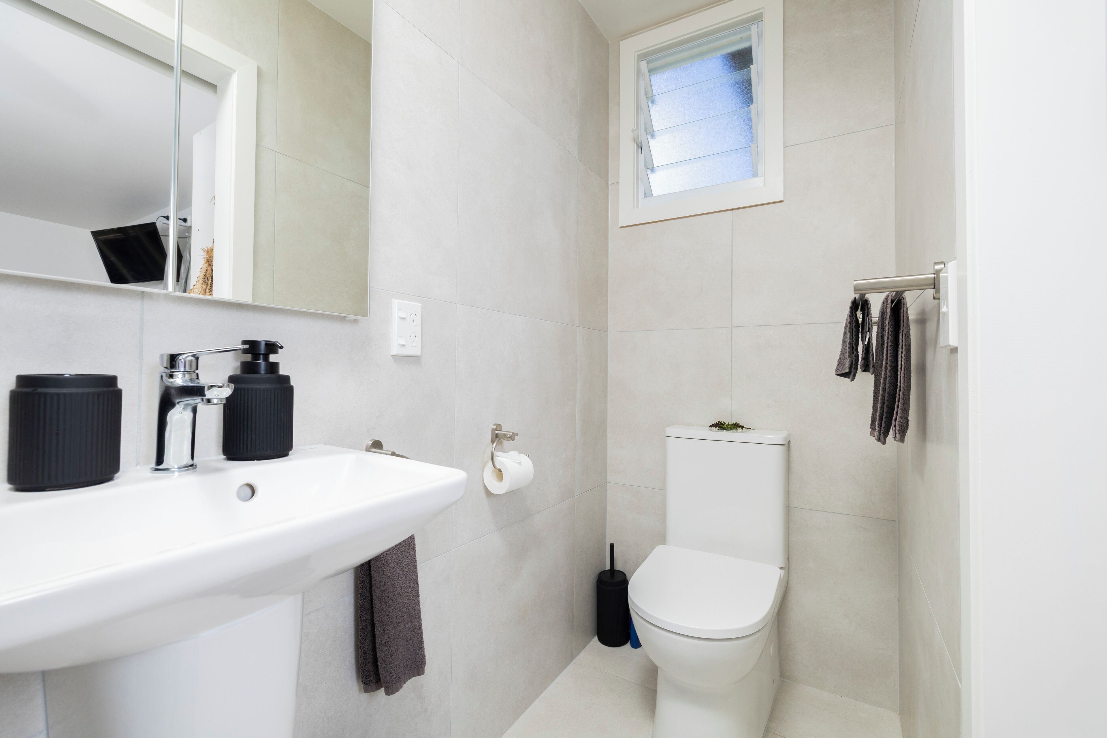 Une salle de bain avec un lavabo blanc, des toilettes et un espace douche.