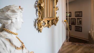 Eine Statue mit einer Goldkette in einem Zimmer mit Holzboden und einer Treppe.