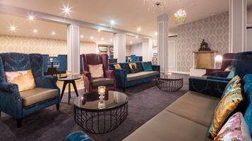 A spacious living room with plush seating, a chandelier, and a fireplace.