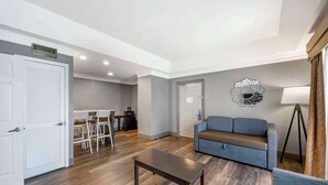 Amplia sala de estar con sofá, mesa de centro y comedor con sillas y una mesa.
