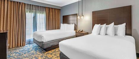 A hotel room with two beds, a nightstand, a telephone, and a patterned carpet.