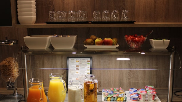 Buffet de café da manhã com diversas opções de comida, bebidas e utensílios.