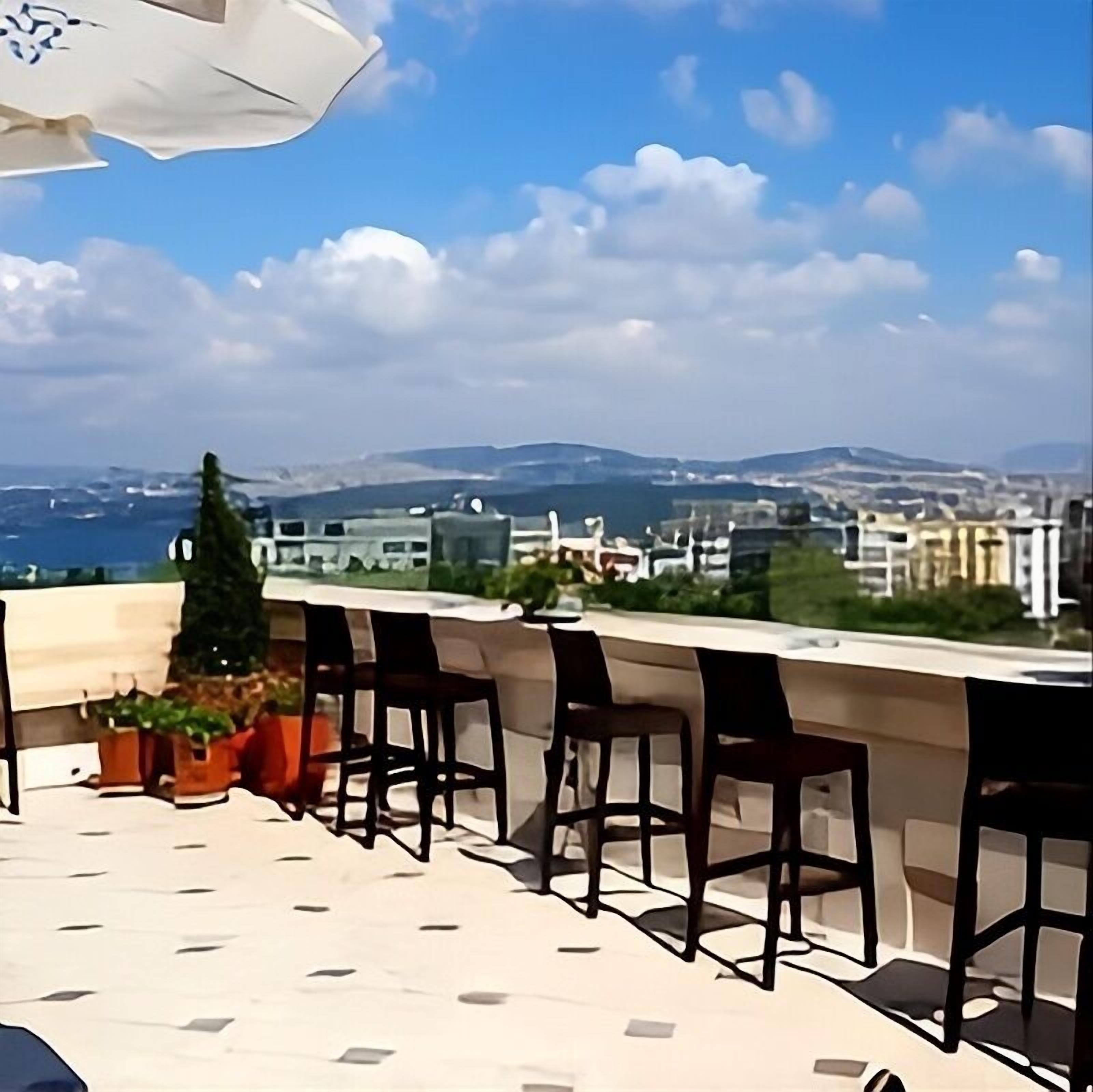 Una terrazza con vista su una città e montagne.