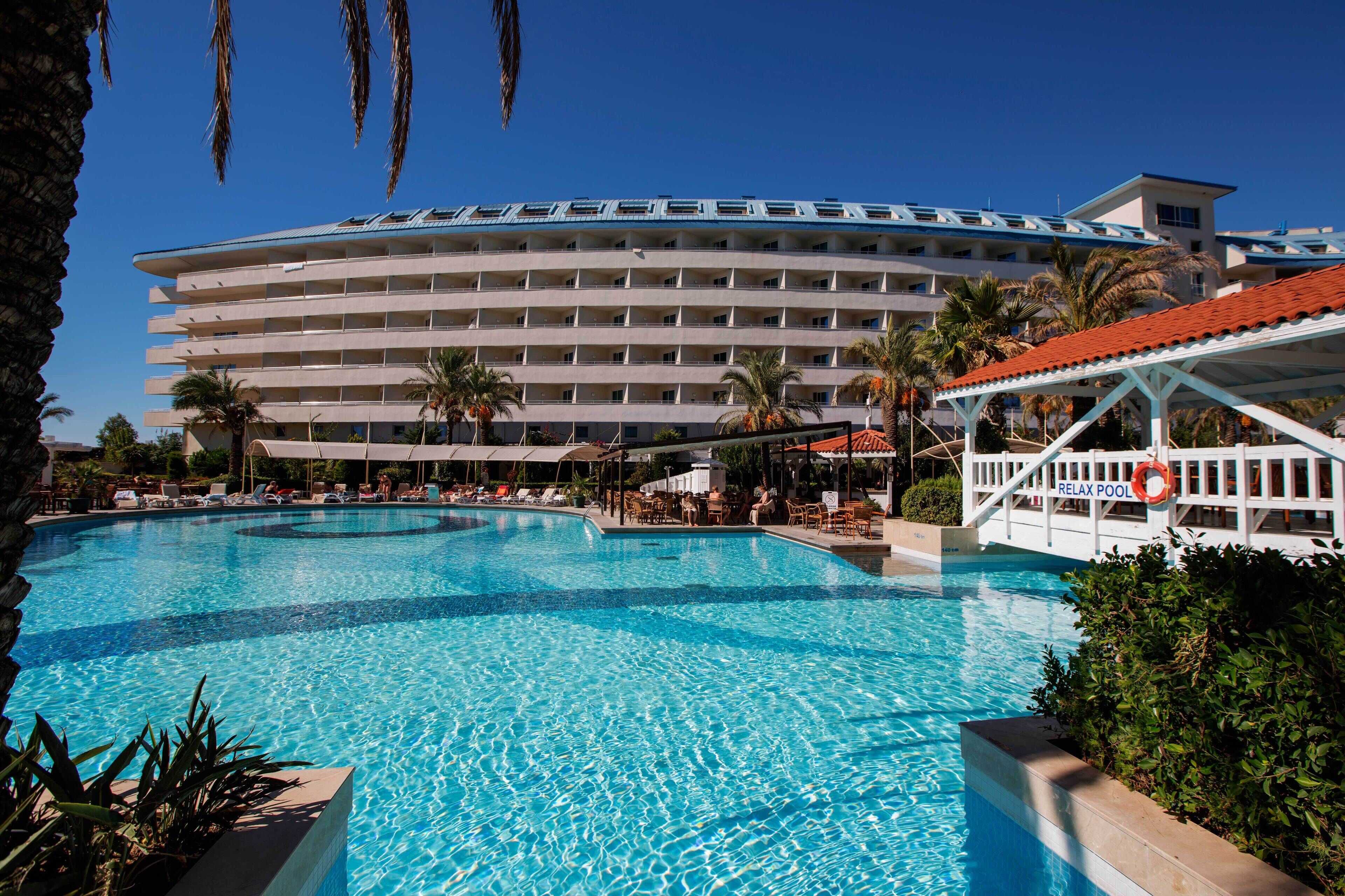Un hôtel doté d’une grande piscine, de nombreux balcons et d’un poste de surveillance pour les sauveteurs.