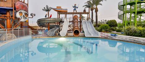 Una piscina con toboganes y un parque acuático con temática pirata.