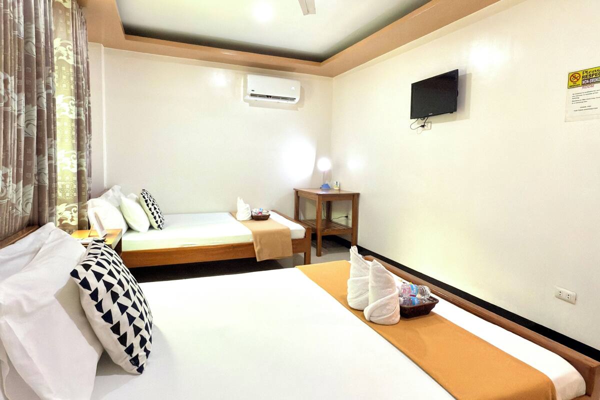 Ein Hotelzimmer mit Bett, Nachttisch und Deckenventilator.