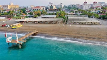 Aan een privéstrand, ligstoelen, parasols, strandlakens