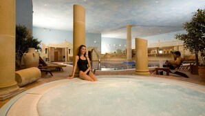 A spa area with a hot tub, columns, and lounge chairs. - Whittlebury Hall Hotel & Spa (Towcester)