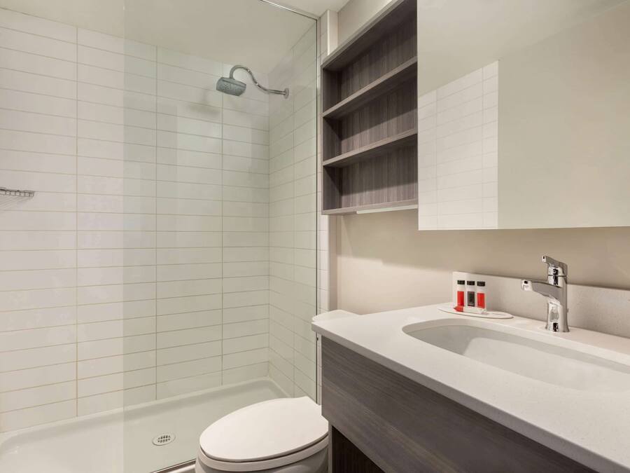 Un baño moderno con ducha, inodoro y lavamanos.