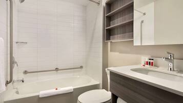 Un bagno moderno con vasca, water e lavandino.