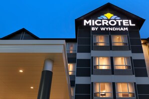 A modern building with the sign "MICROTEL BY WYNDHAM" on the facade.