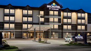 Un hotel Microtel by Wyndham con un diseño moderno, que cuenta con una entrada amplia y múltiples ventanas.