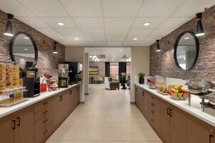 Un área de cocina moderna con una encimera larga, electrodomésticos integrados y un espacio de estar al fondo.