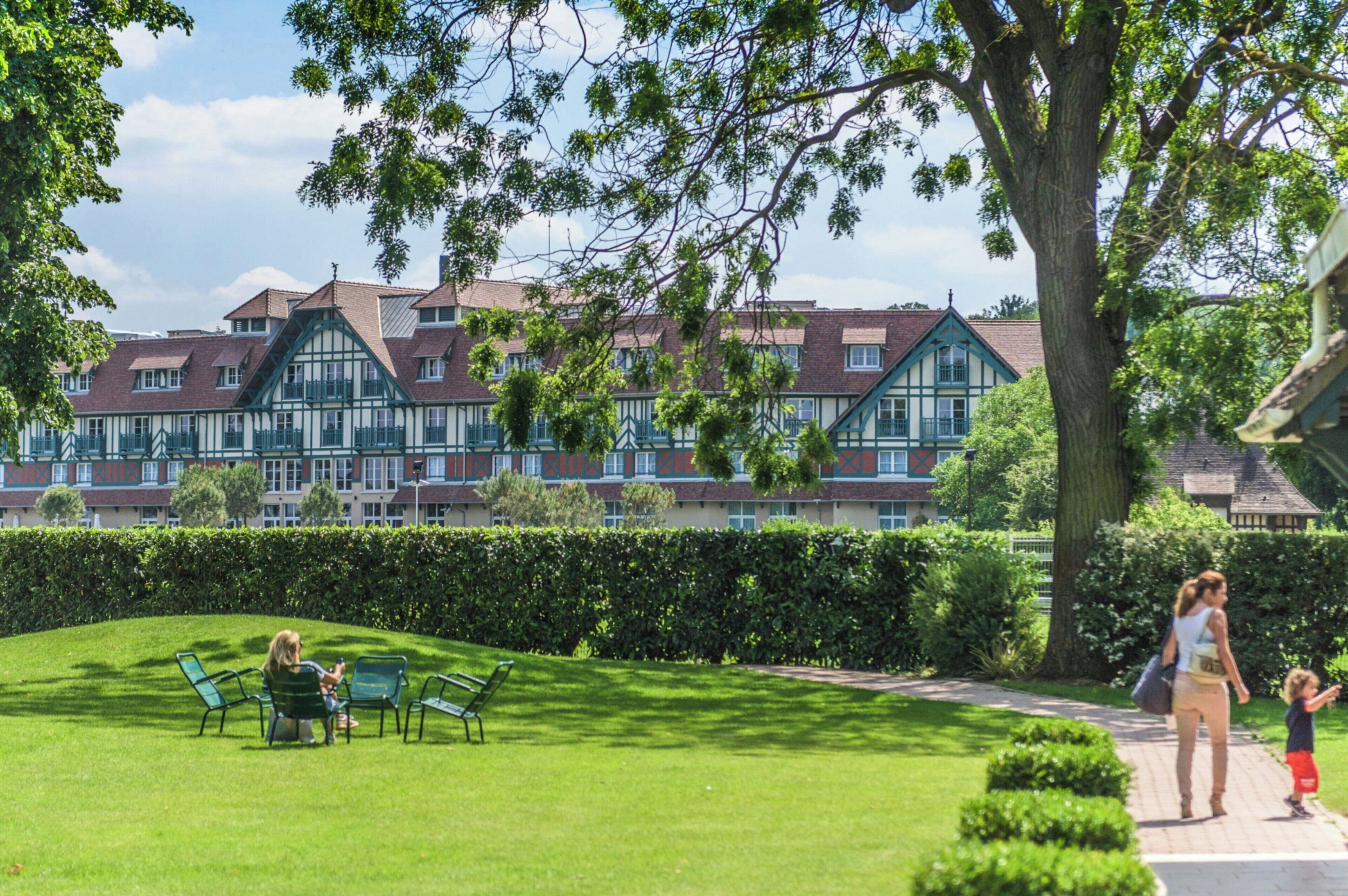 A courtyard with a lawn, benches, and a pathway.