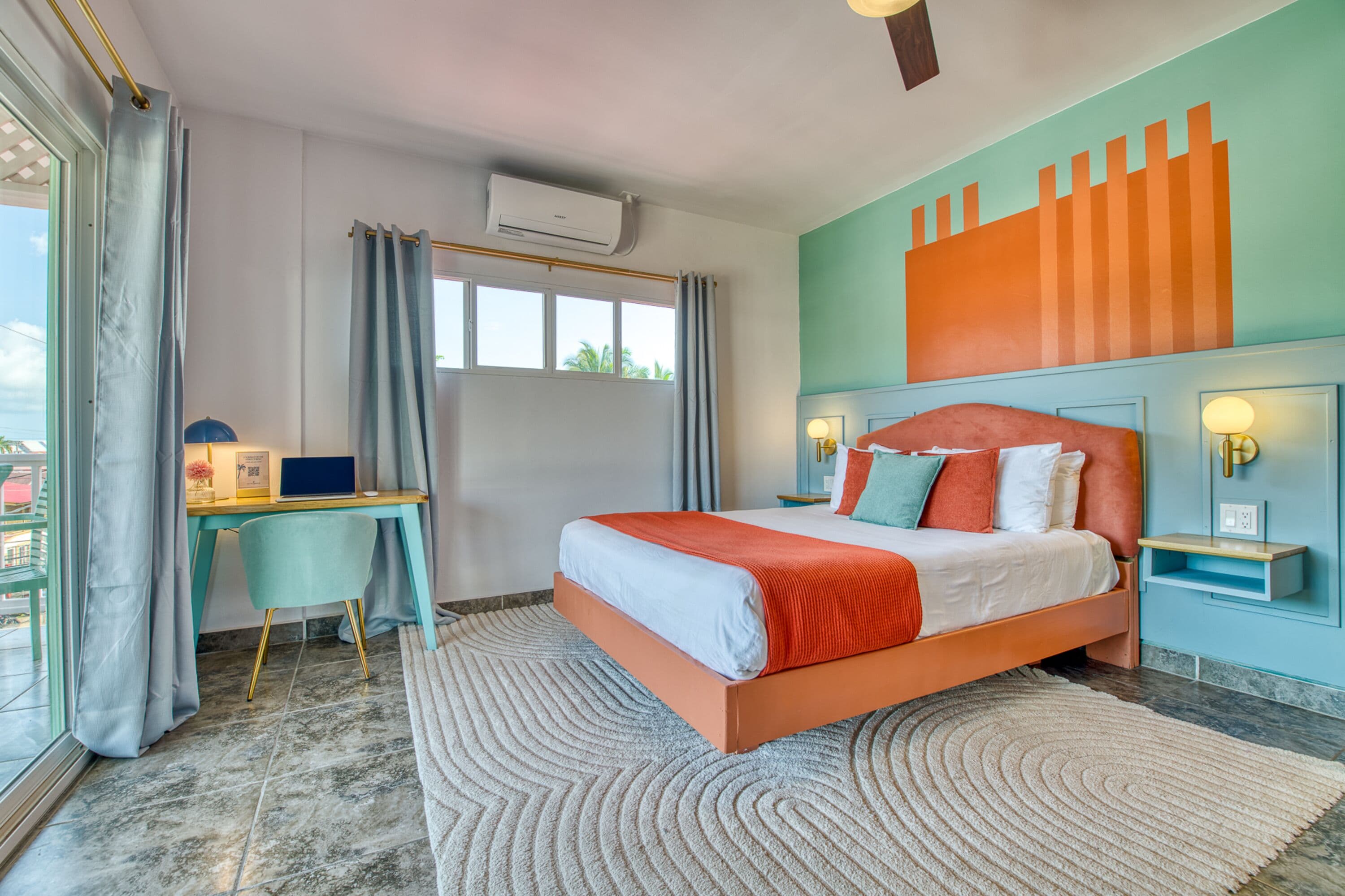 Un dormitorio moderno con una cama grande, un escritorio y vistas al exterior.