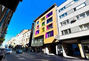 A multi-story building with a modern design, featuring large windows and a flat facade. - Colors Inn (Sarajevo)