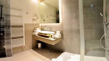 Une salle de bain moderne avec une douche à parois de verre, un meuble-lavabo avec un miroir et une baignoire.