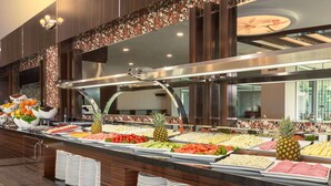 A buffet with various food items and stacked plates. - Ramada by Wyndham Usak (Usak)