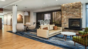 A modern lobby with a stone fireplace, comfortable seating, and a large artwork on the wall.