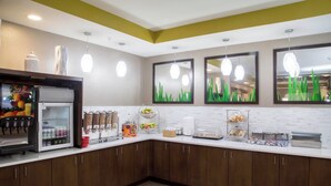 A modern kitchen with a refrigerator, coffee maker, and various food items on the counter. - TownePlace Suites Oxford (Oxford)