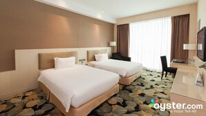 Une chambre d’hôtel avec deux lits, un bureau, une chaise et un téléviseur.