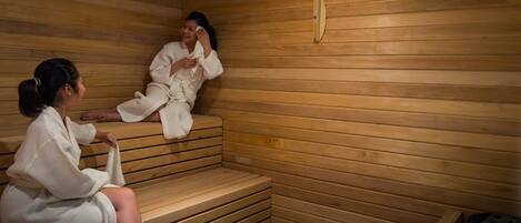 A wooden sauna with benches and a bench for sitting.
