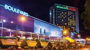 Un hôtel moderne, reconnaissable à son grand panneau indiquant « Boulevard » et à l’enseigne « Imperial Hotel ».