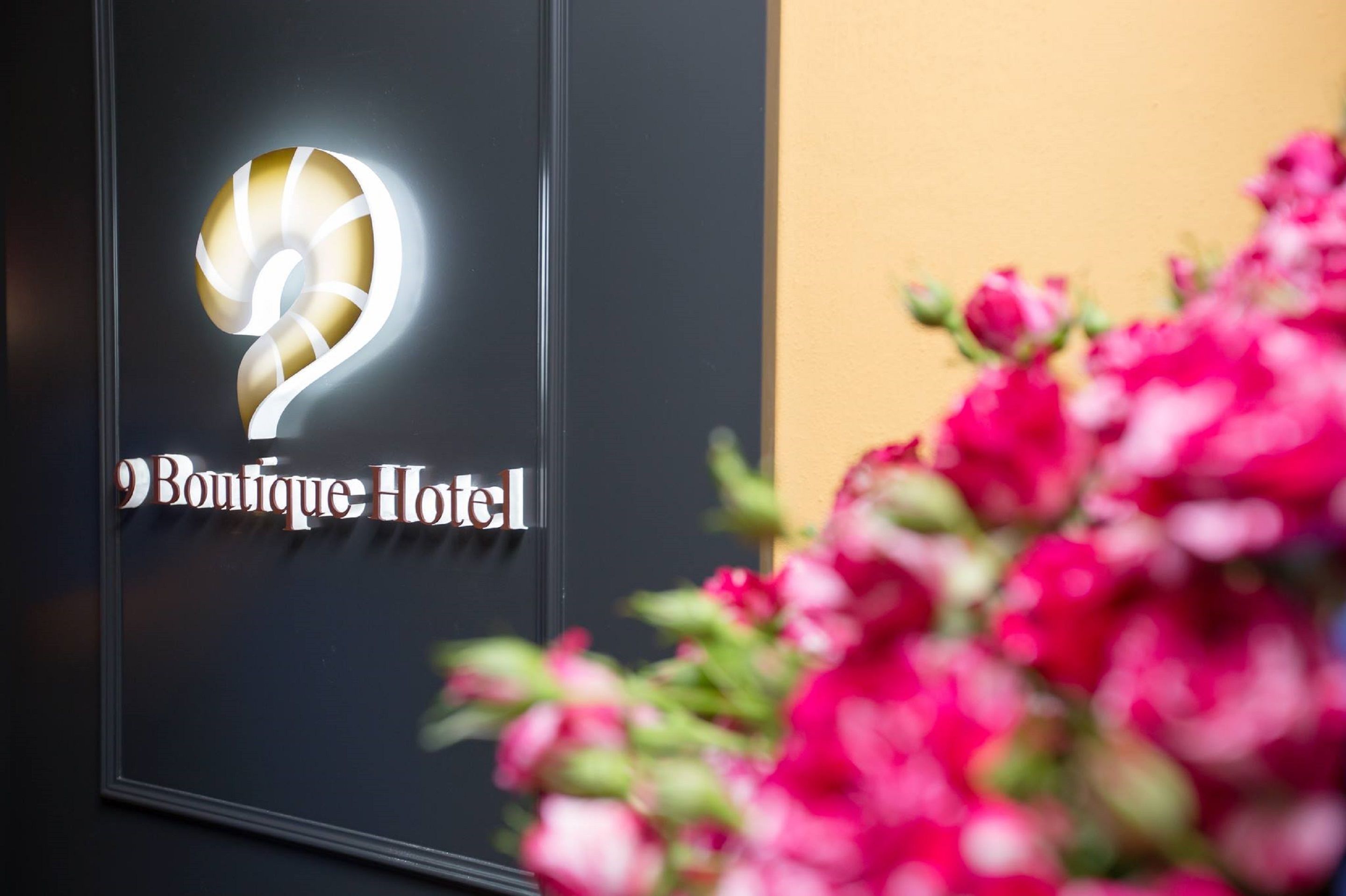 A sign for Boutique Hotel with a stylized number '2' and the hotel name.