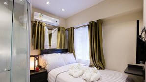 A hotel room with a bed, a bedside table with a lamp, a mirror, and a window with curtains. - 9 Boutique Hotel (Hong Kong)