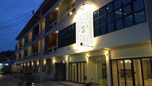 Un hotel de varios pisos con un letrero llamativo y una entrada bien iluminada.