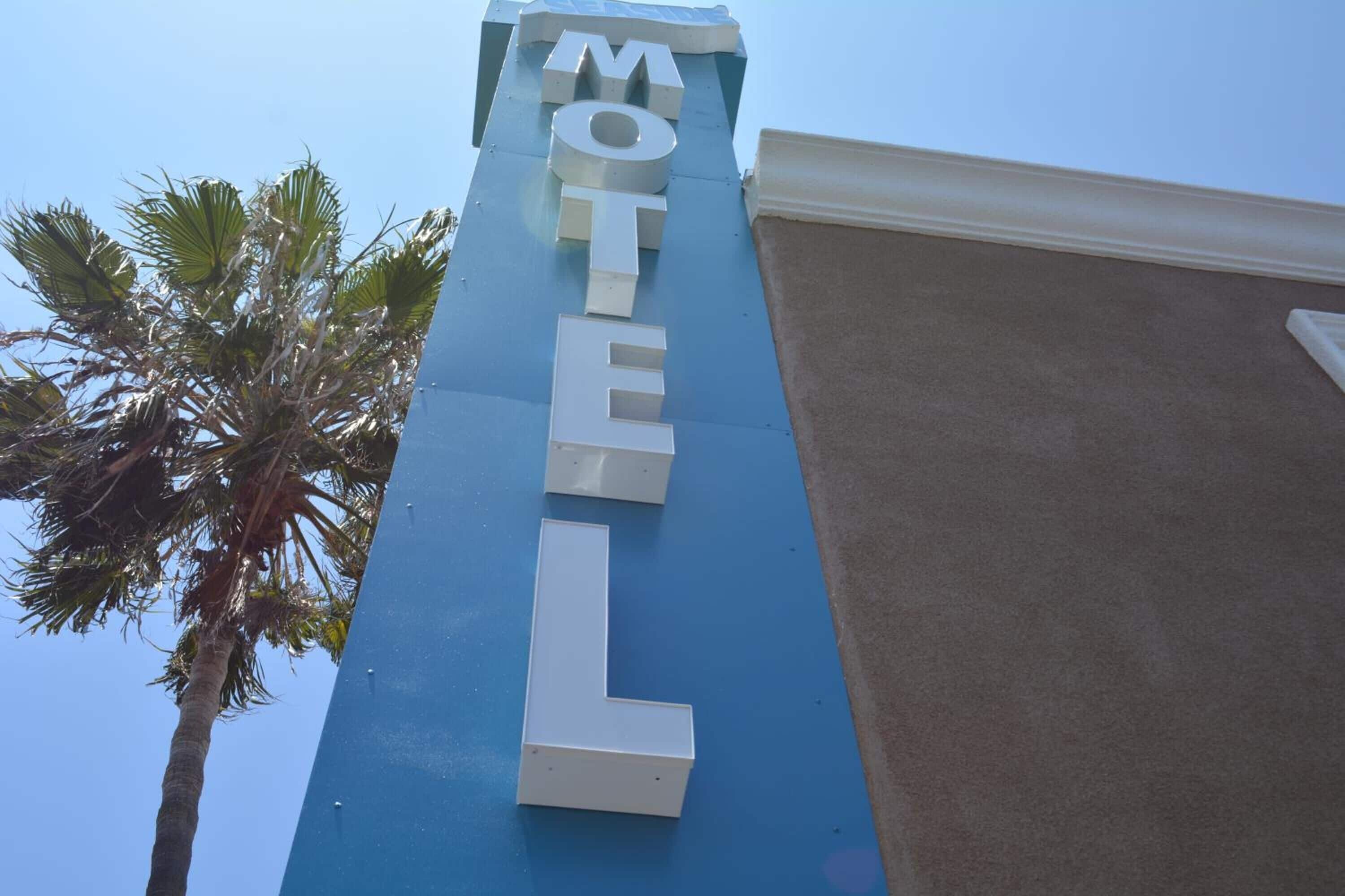 A motel sign with the word "MOTEL" in large white letters on a blue background.