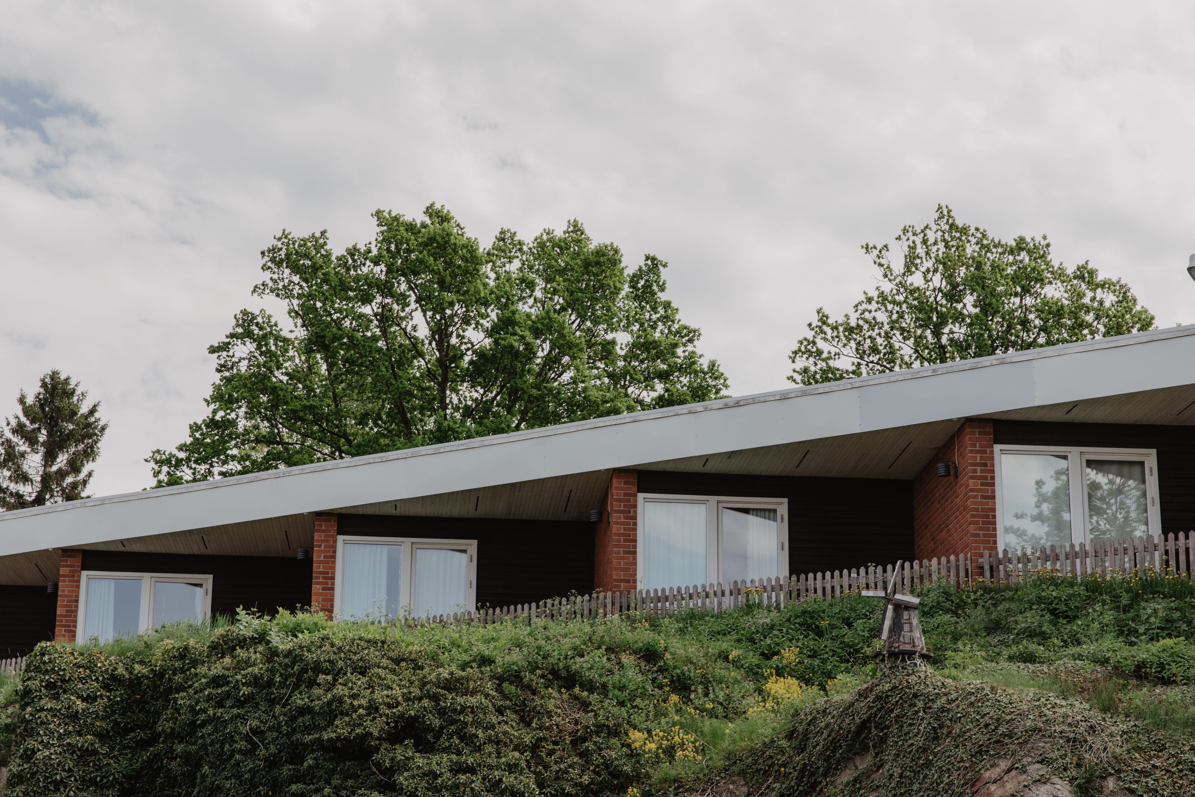 A modern building with a flat roof, brick walls, and large windows.