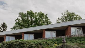 A modern building with a flat roof, brick walls, and large windows.